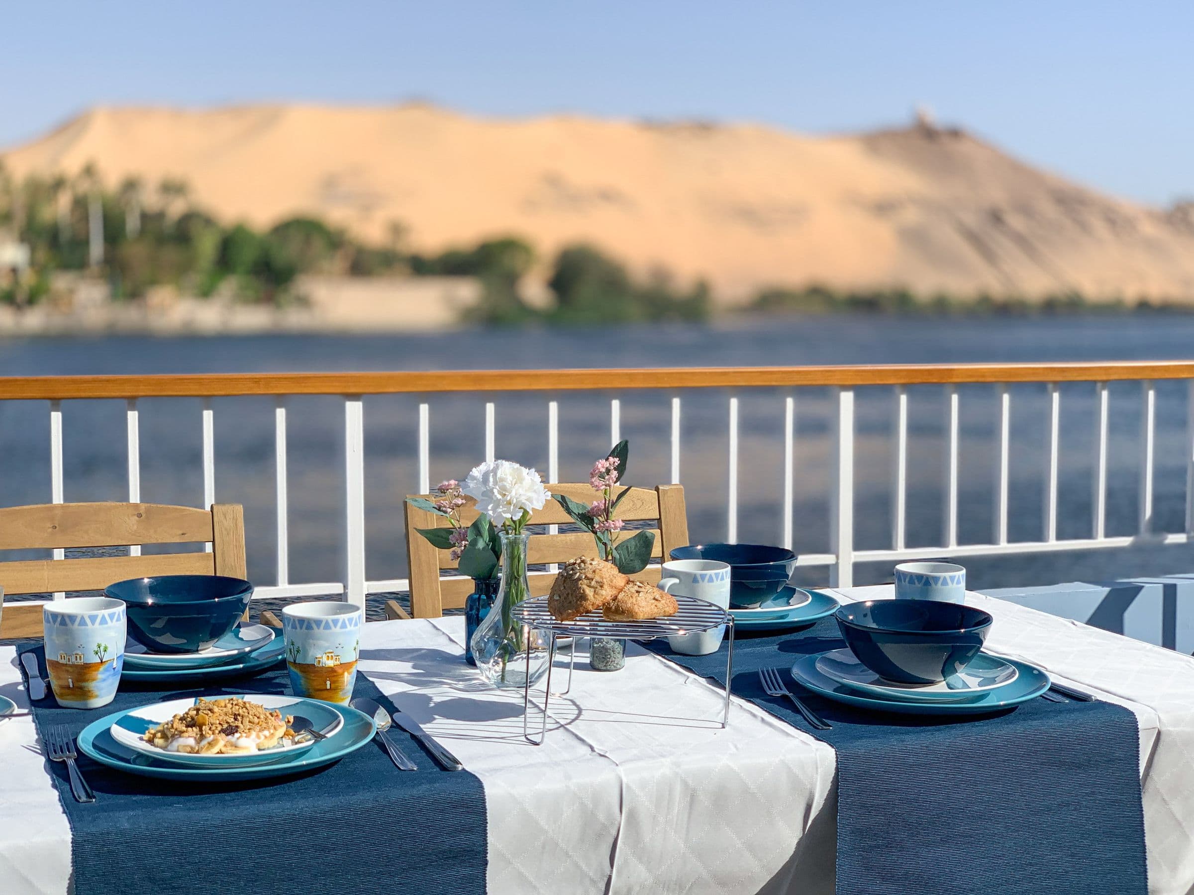 Breakfast served on deck with the desert dunes across the river