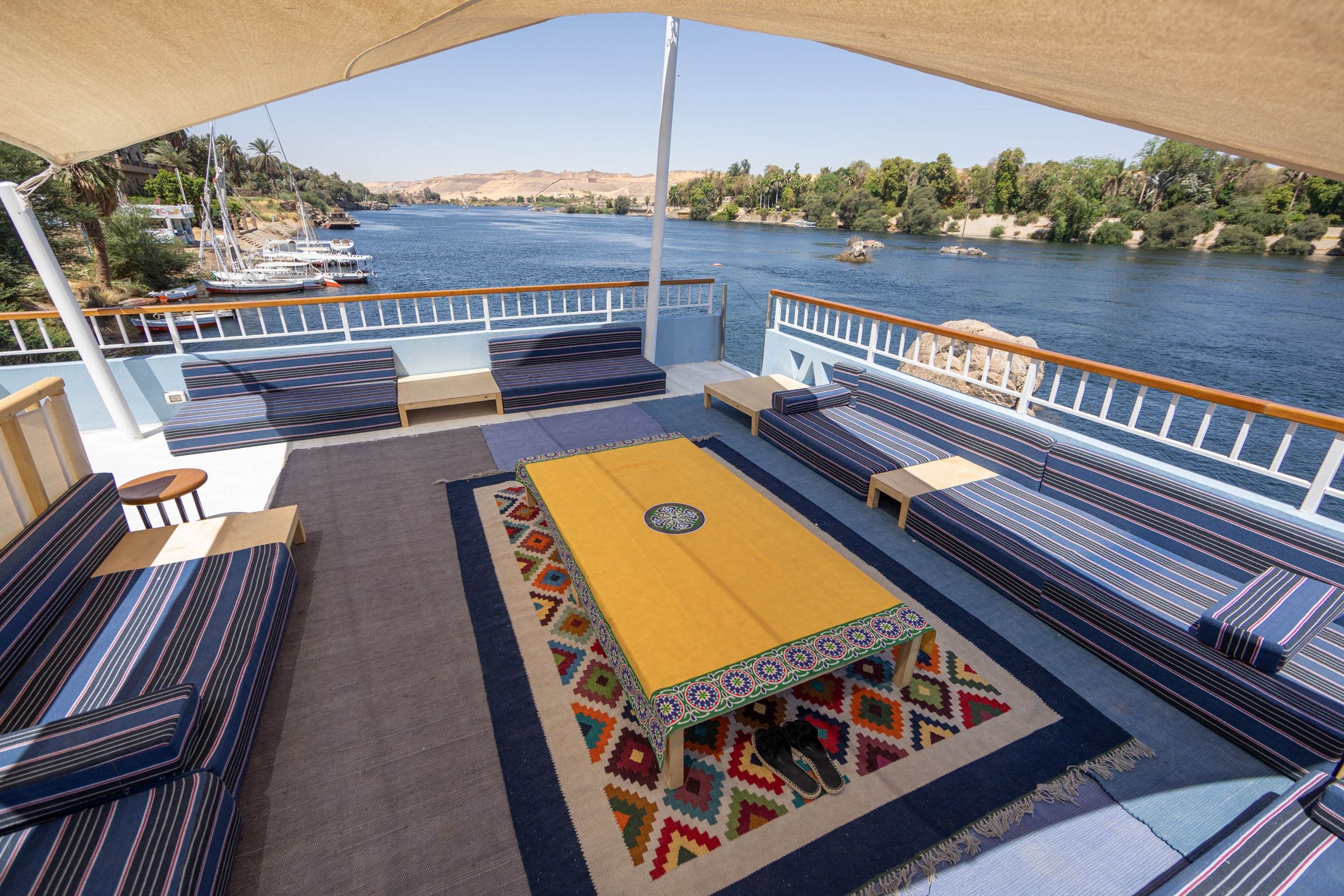 Anakob’s shaded sundeck with Nubian textiles, looking across the Nile