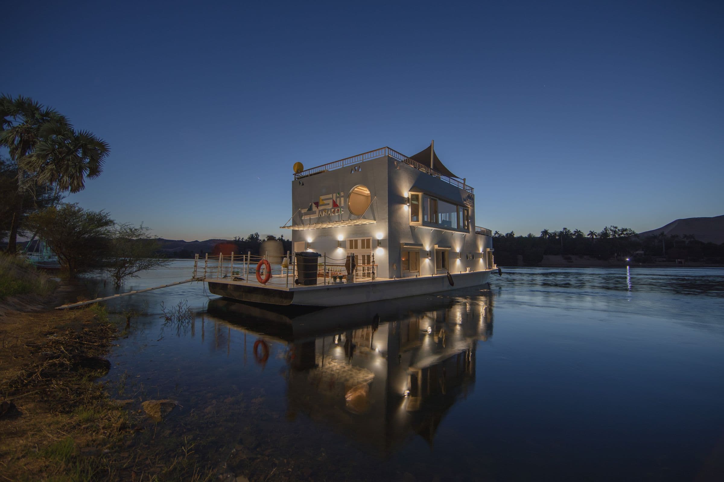 Anakob lit up on the still Nile at blue hour