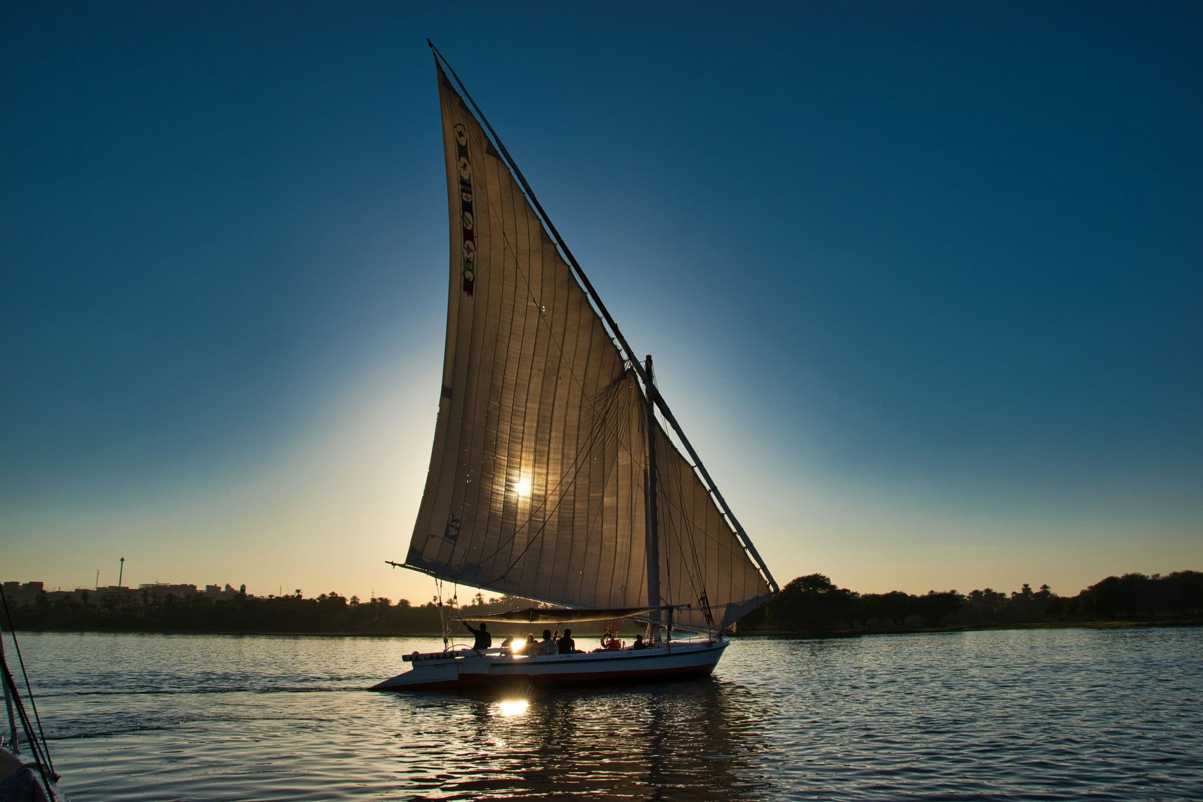 A felucca under full sail on the Nile at golden hour